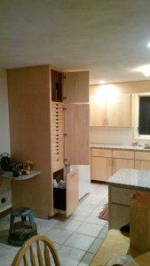 Custom vertical cabinet with 13 small drawers, tray storage and a pull out trash drawer.